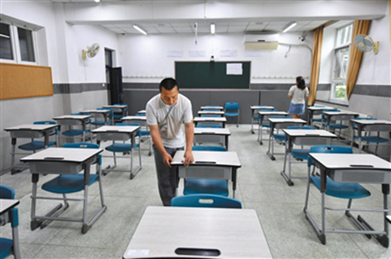 6月6日，北京一零一中學考點，監考老師在考場貼桌簽。李木易/攝
