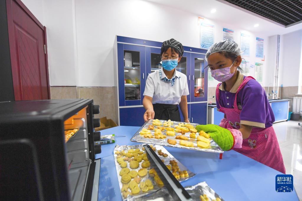 6月24日，在包頭市昆都侖區包鋼第十七小學，學生們利用課余時間學習烘焙。