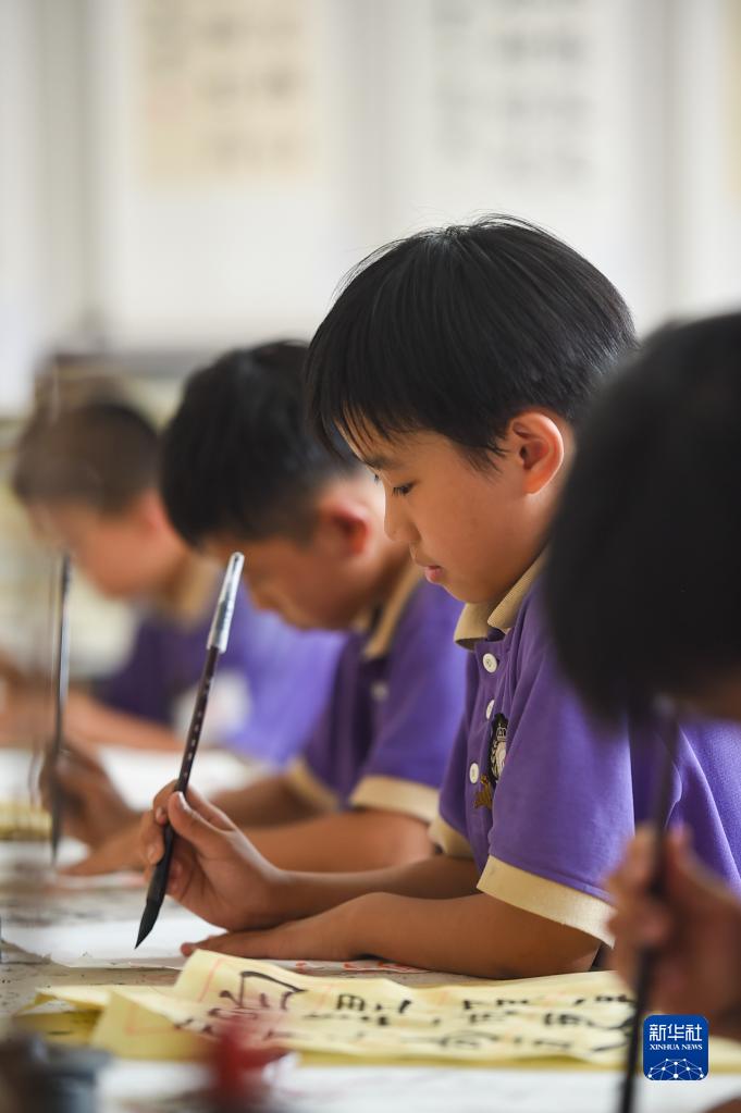6月24日，在包頭市昆都侖區包鋼第十七小學，學生們利用課余時間學習書法。