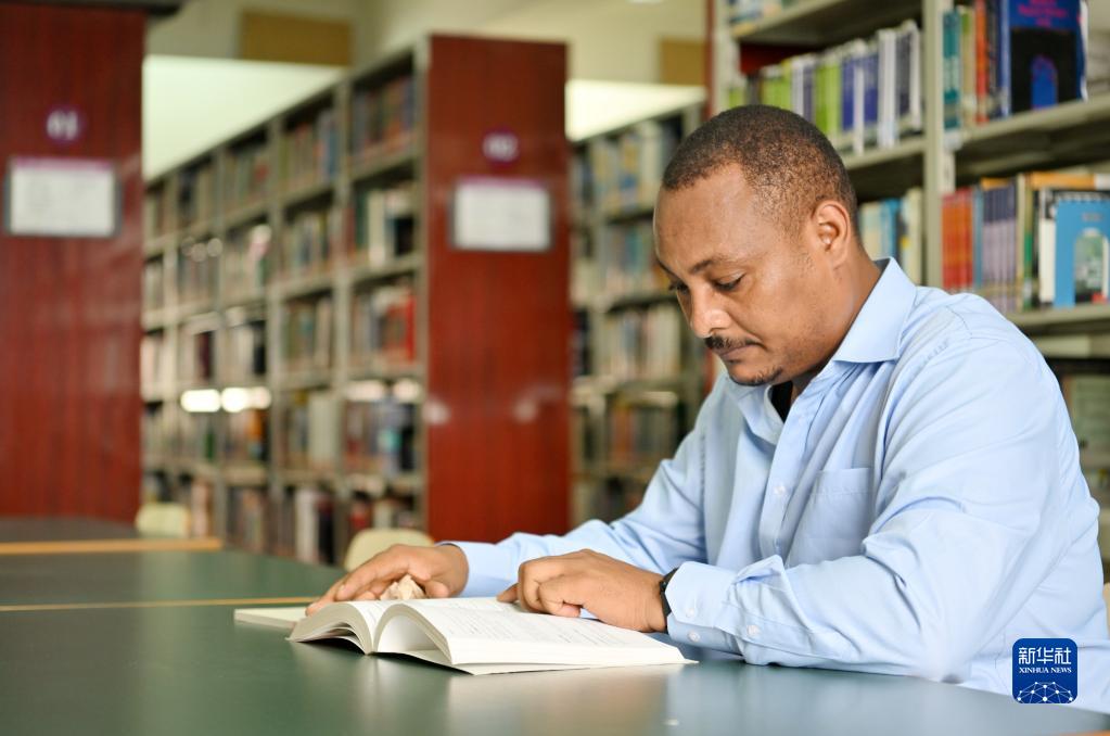 在天津職業技術師范大學圖書館，韓士蘭翻閱外文書籍（8月12日攝）。新華社記者 李然 攝