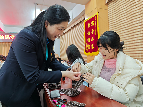 學生在老師指導下，體驗縫補收納。