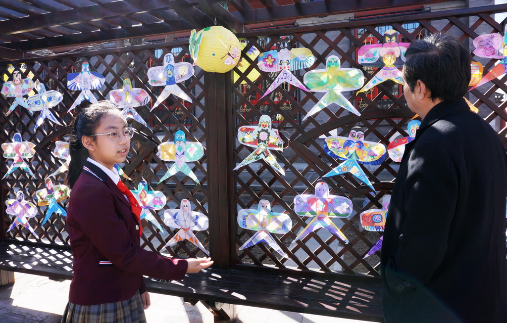 3月24日，府學胡同小學學生向來賓介紹同學們繪制的風箏。