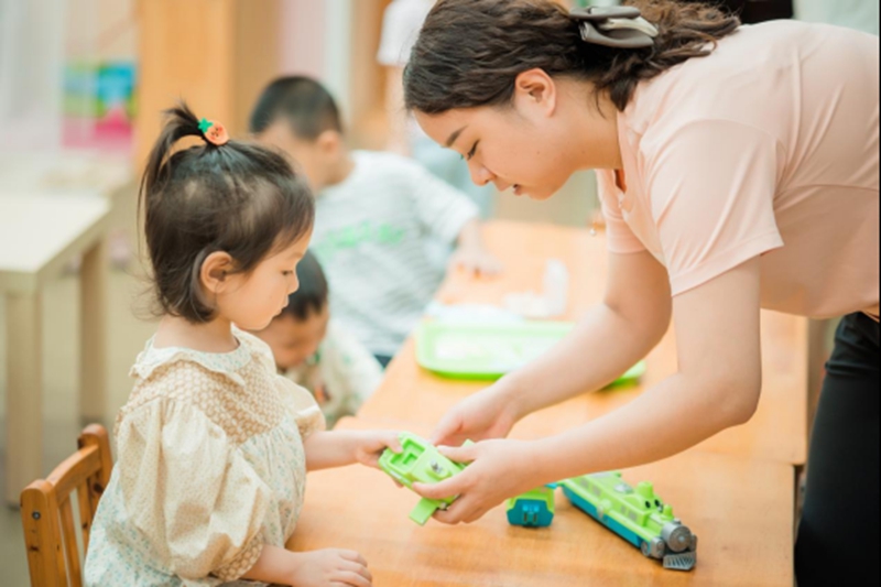 教師與孩子一起玩玩具。園方供圖