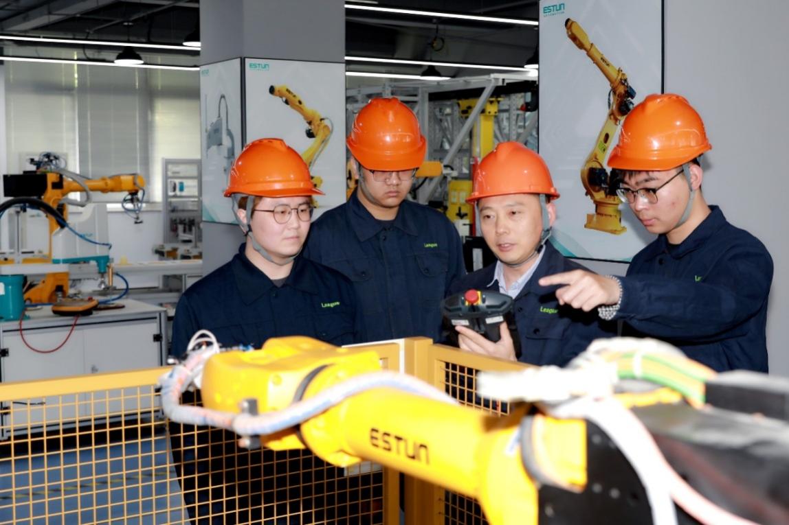 教師正在指導企業員工進行機器人編程與運維。學校供圖