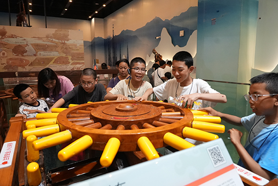 西藏少年兒童在中國科技館參觀井車模型。中國兒童中心供圖