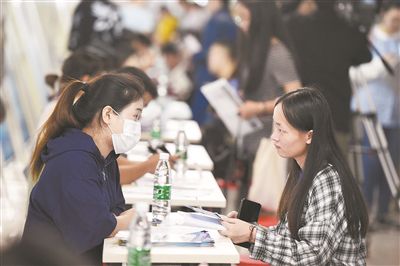 在由安徽合肥經濟技術開發區人力資源中心主辦的招才引智活動上，求職者（右）向用人單位工作人員了解招聘信息。新華社記者 黃博涵攝