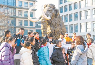 圖為科研人員為學生講解科學家“復活”猛犸象的最新進展。張進剛攝