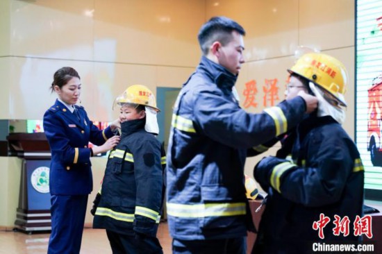 圖為學生們現場穿戴消防頭盔和戰斗服。中新社記者 趙宇航 攝