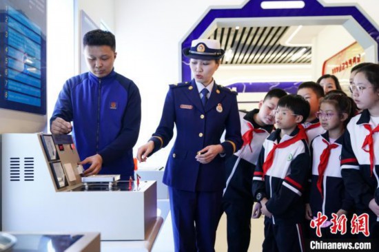 圖為學生們參觀道里區消防救援大隊消防科普體驗館內電器火災演示實驗臺。中新社記者 趙宇航 攝