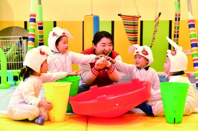 在山東省日照市東港區一家托幼園，老師陪伴孩子做游戲。新華社發