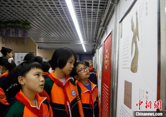 圖為學生參觀青海省博物館“1+3”主題流動展覽，了解木舞俑。中新社記者 馬銘言 攝