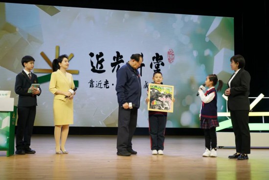 平谷六小版畫社團的學生代表贈送手工作品《平谷彩韻》，展現了平谷桃花海美景。