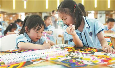 圖為小朋友在制作紙鳶。本報記者 何亮攝