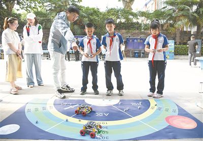 圖為在西安市新城區華山實驗小學，學生在老師的指導下進行機器人游戲。 新華社記者 張博文攝