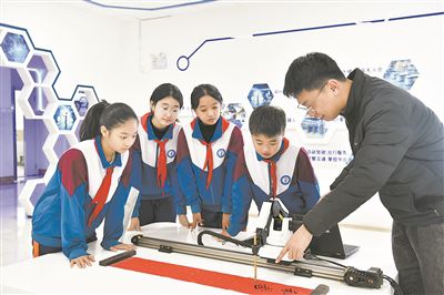 在山東日照金海岸小學，老師指導學生練習機械臂毛筆書寫編程。新華社記者 郭緒雷攝