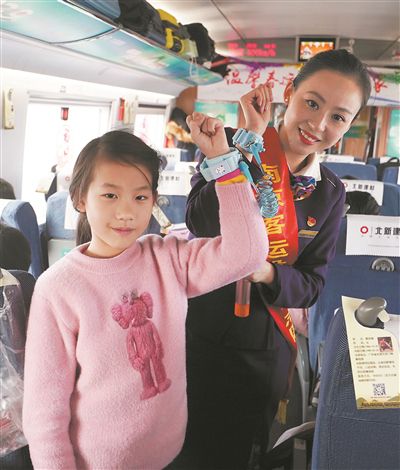 列車工作人員和小乘客展示防走失兒童專用手環。