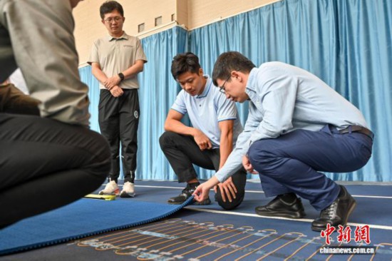 圖為蘇炳添在訓練基地內了解數字化跑道分析系統。中新社記者 陳驥旻 攝