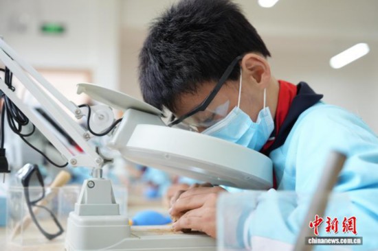 一名小學生正在清理“化石”上的泥土。劉鴻鶴 攝