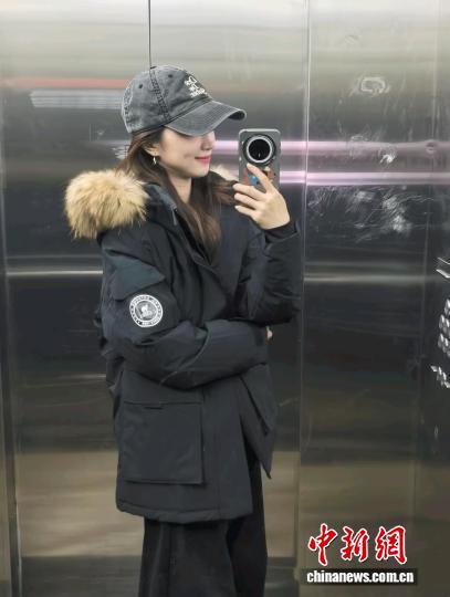 張洛齊身著今年“雙十一”剛開啟時買的羽絨服，這件羽絨服原價890元，折后830元買的。 受訪者供圖