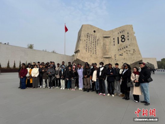 11月5日，來自俄羅斯、埃塞俄比亞等國家的40余名留學生走進沈陽二戰盟軍戰俘營舊址陳列館和沈陽“九· 一八”歷史博物館參觀。圖為留學生在沈陽“九· 一八”歷史博物館殘歷碑廣場合影。中新社記者 韓宏 攝
